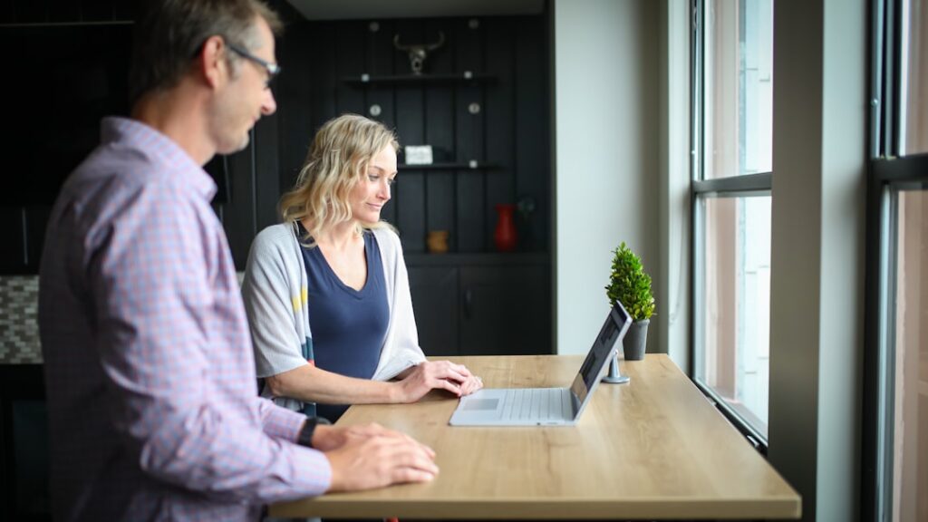 Client and a real estate agent having a professional discussion in a bright, modern office, symbolizing the realtor vettin...