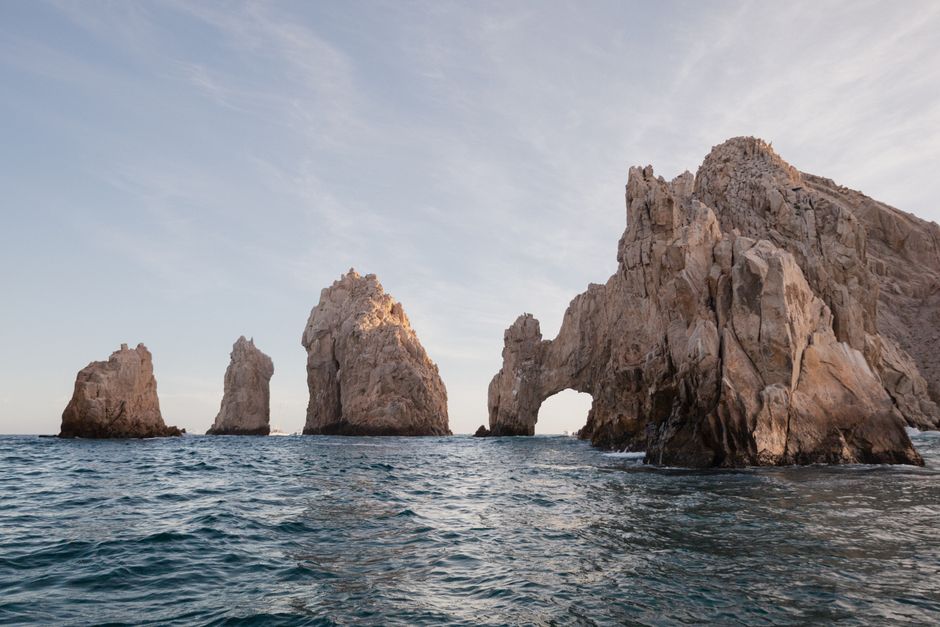 Aerial view of the stunning Los Cabos coastline, where the arid desert landscape meets the bright turquoise ocean under a ...
