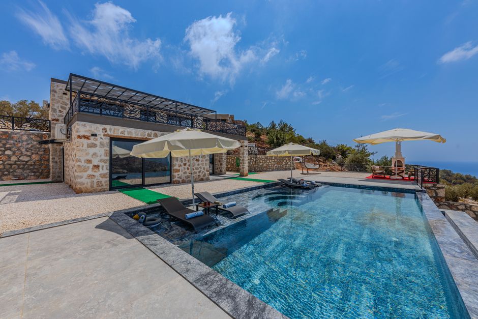 A modern luxury villa in Los Cabos featuring a stunning infinity pool that overlooks a spectacular ocean view.