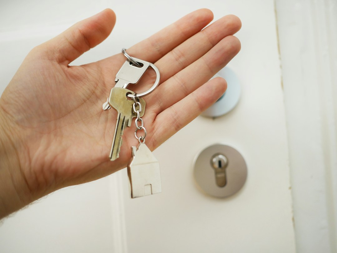 A smiling homeowner hands a set of keys to a delighted guest at the doorway of a rental home, symbolizing a successful and personal direct booking experience.